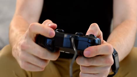 hombre jugando un juego de joystick en el sofá 4k