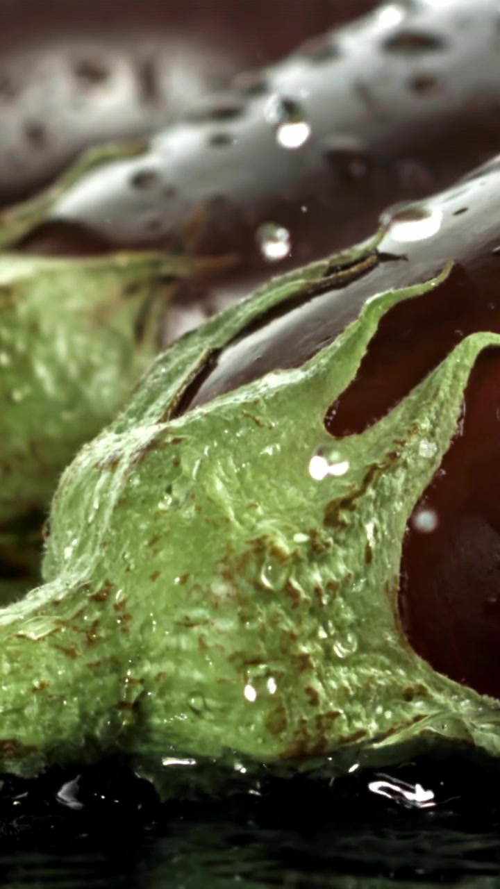 Melanzana fresca con gocce d'acqua che schizzano al rallentatore