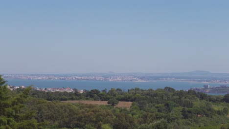 a panoramic view of tejo river from the top of monsanto park in lisbon