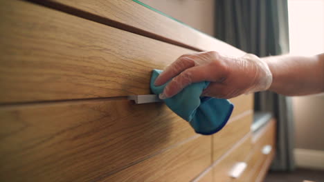 the maid efficiently goes about her tasks, tidying up the hotel room with precision and care, by wiping and cleaning everything in a hotel room