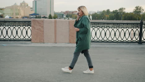 woman talking on phone while walking in the city