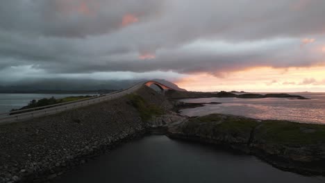 moviéndose hacia la carretera del océano atlántico atlanterhavsveien en noruega con una espectacular puesta de sol y nubes que cubren las montañas