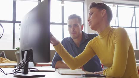 Happy-caucasian-business-people-sitting-at-table-and-discussing-work-at-office