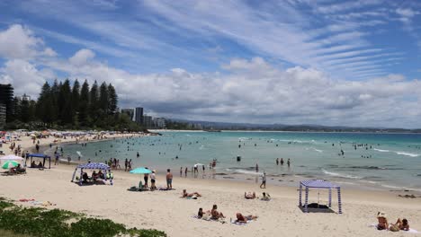 crowded beach scene with changing cloud patterns