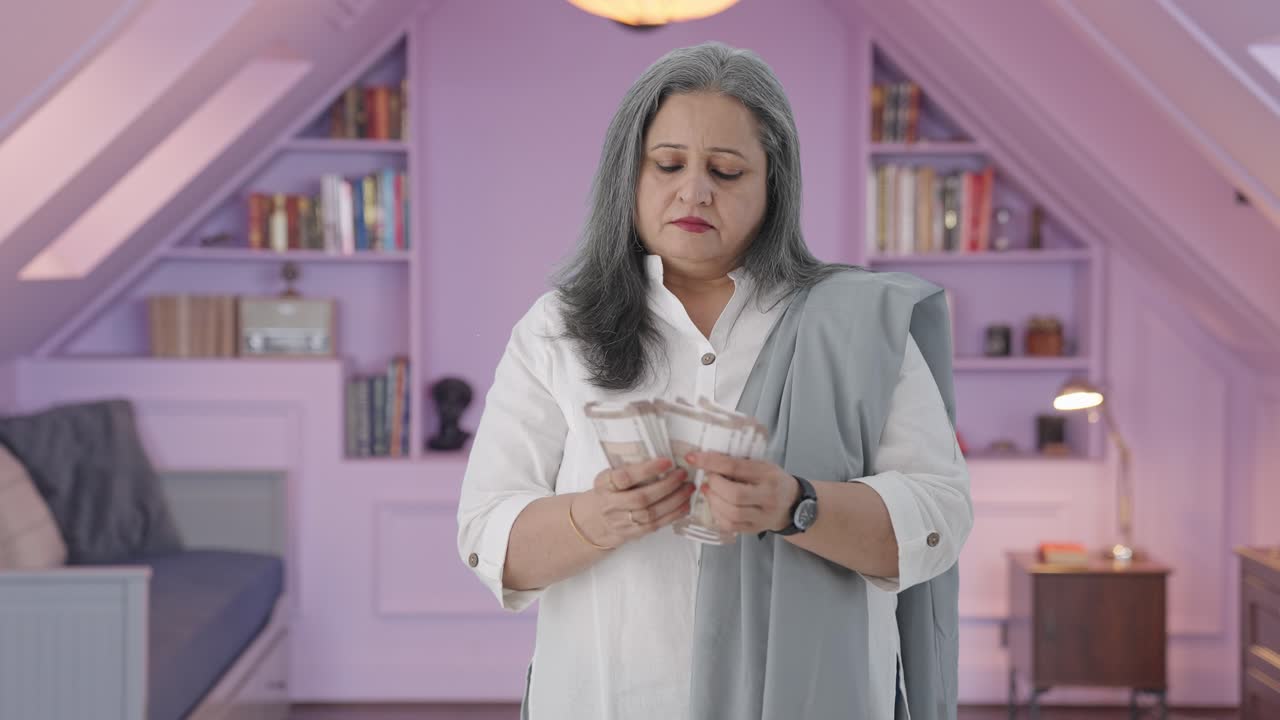 Ibu India serius menghitung uang