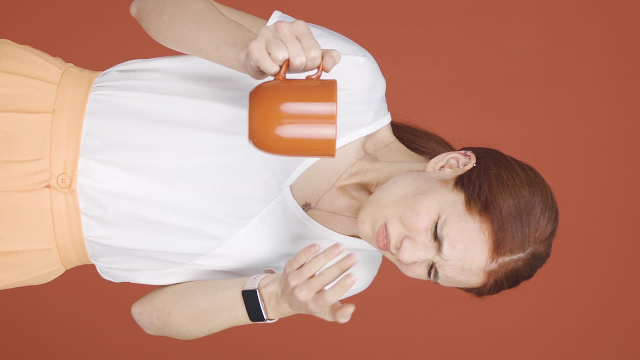 Vertical video of The woman's mouth is burning from the hot drink.