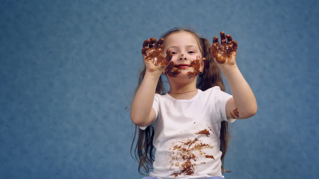 Portrait of girl with chocolate. Small girl with chocolate smeared all over her face and fingers