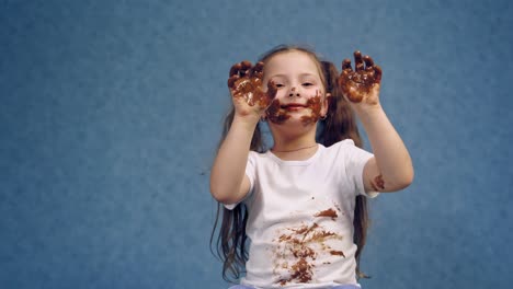 portrait of girl with chocolate. small girl with chocolate smeared all over her face and fingers