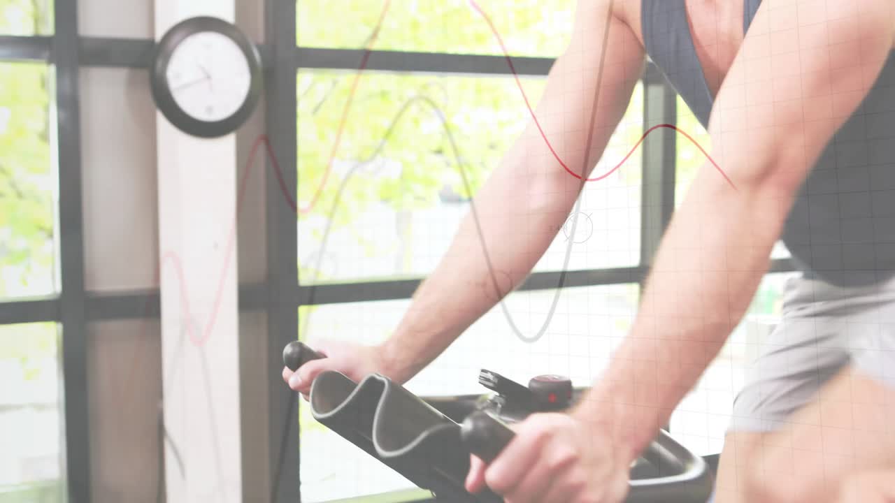 Cyclists gripping handlebars in gym initiating sync pedaling with heartrate wires by glass window