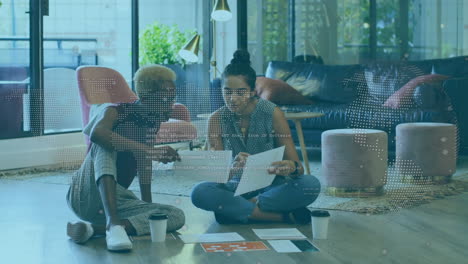 animation of globe and data over diverse women working in office