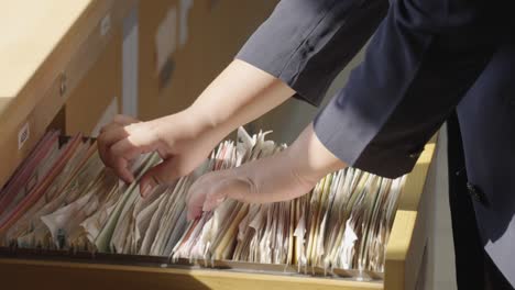 female staff searching for documents in the office filing cabinet