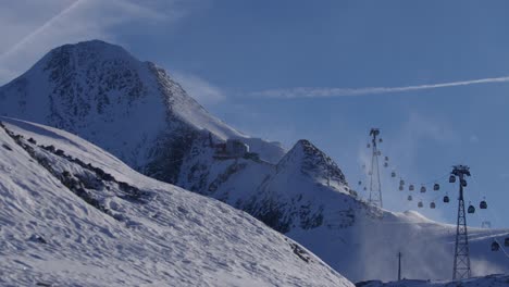 Gondola-lift-bringing-people-up-the-mountain-for-skiing-and-snowboarding-with-a-blizzard-wideshot