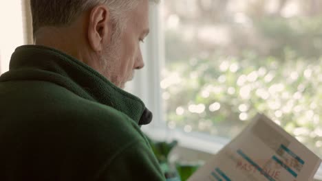 over shoulder of senior citizen looking at past due bills