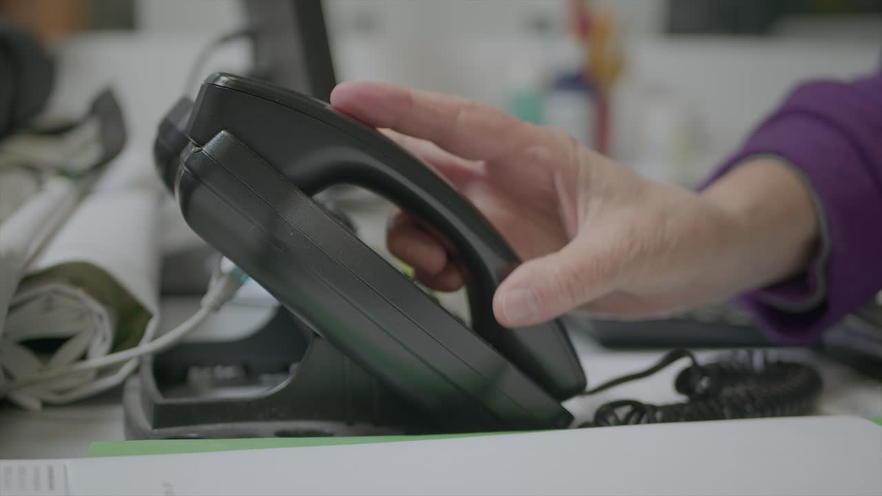 toma en cámara lenta del empleado de la oficina escribiendo y contestando el teléfono del escritorio