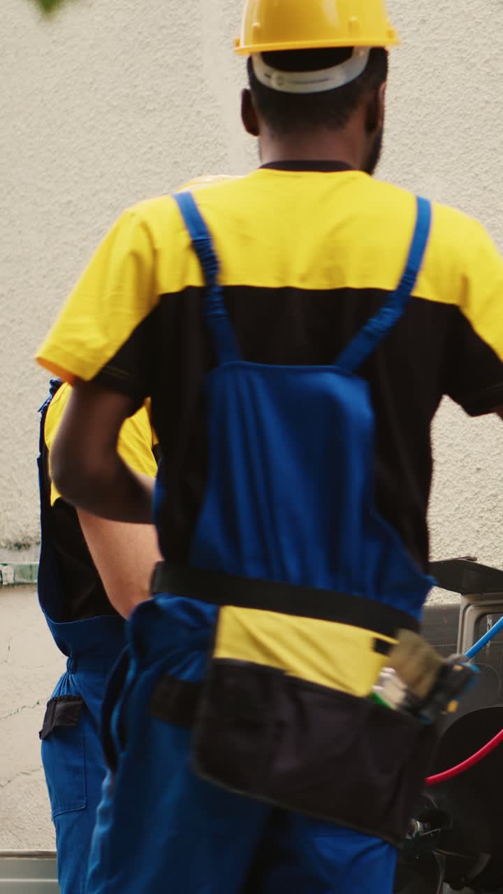 Vídeo vertical. Compañeros revisando el sistema HVAC