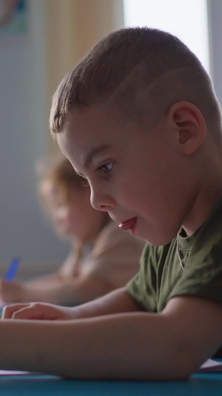 Giovane ragazzo concentrato che studia a una scrivania in un'aula