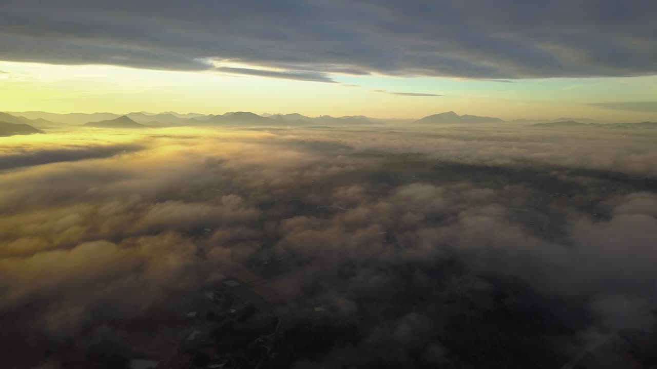 volando por encima de las nubes en el cielo en un amanecer de hora dorada
