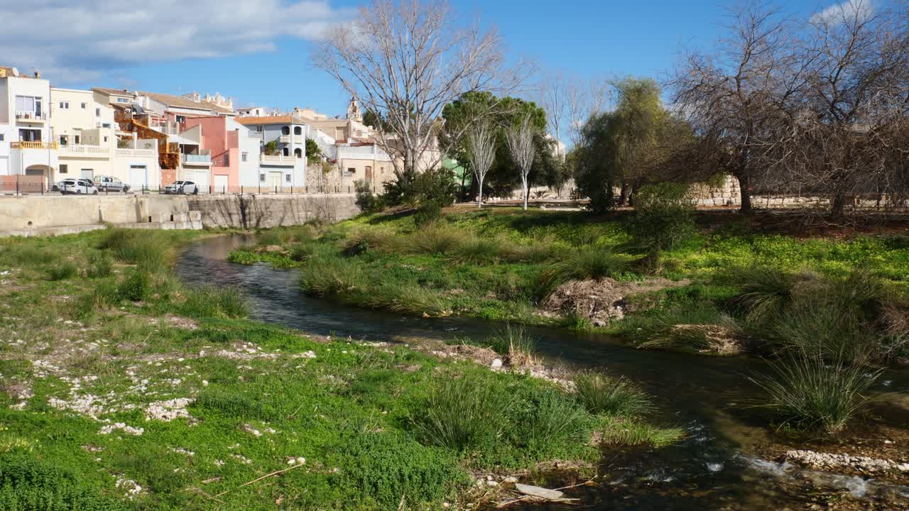 Río apacible fluyendo junto a coloridos edificios en un pueblo encantador