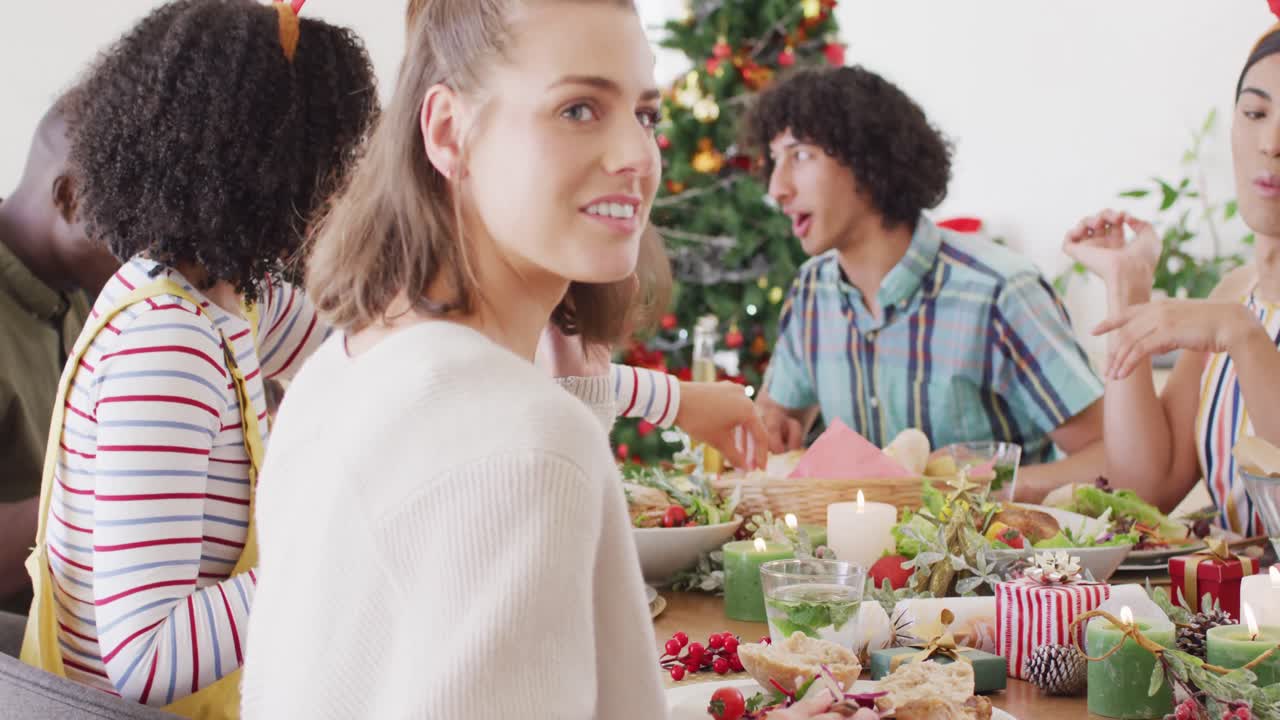 un grupo feliz de amigos diversos sentados a la mesa y cenando juntos