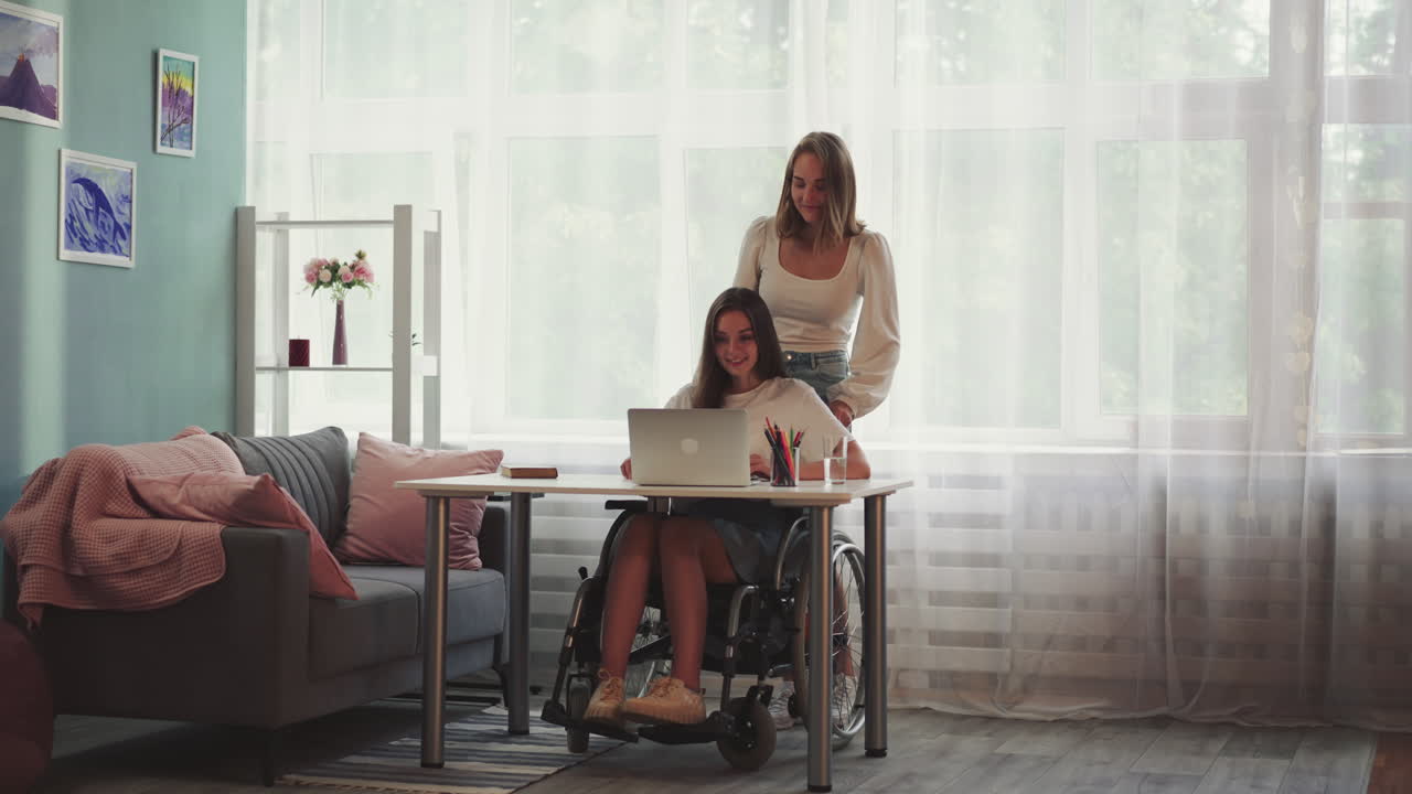 mujer ayuda a su compañera con discapacidad en silla de ruedas a llegar a la mesa