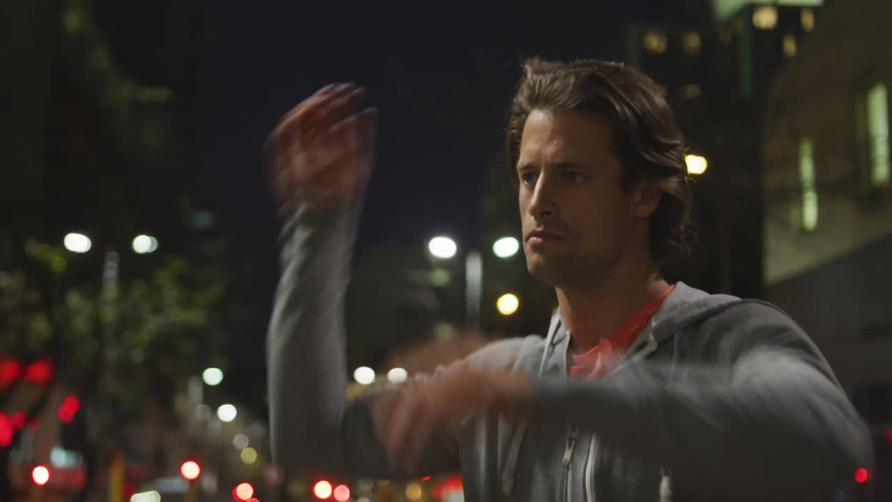 백인 남성이 저녁 밤에 거리에서 스포츠를 하고 있습니다.