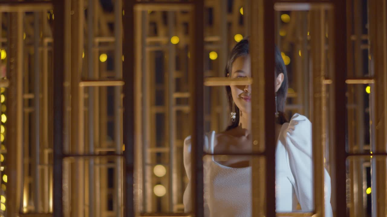 멋진 미소를 지닌 여성은 창밖을 수줍고 애매한 방식으로 바라본다