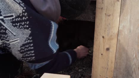 a man is constructing the stove beneath the diy hot tub - close up