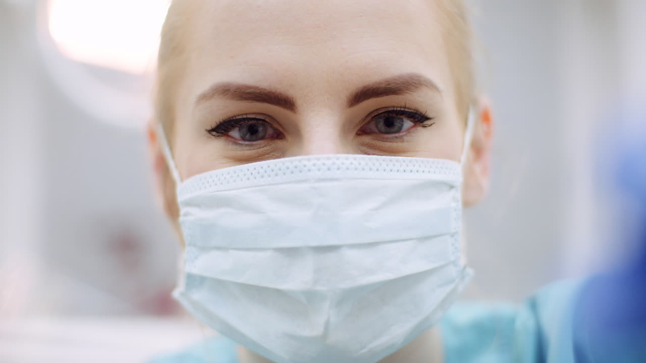primer plano de una dentista mirando al paciente durante la cirugía 2