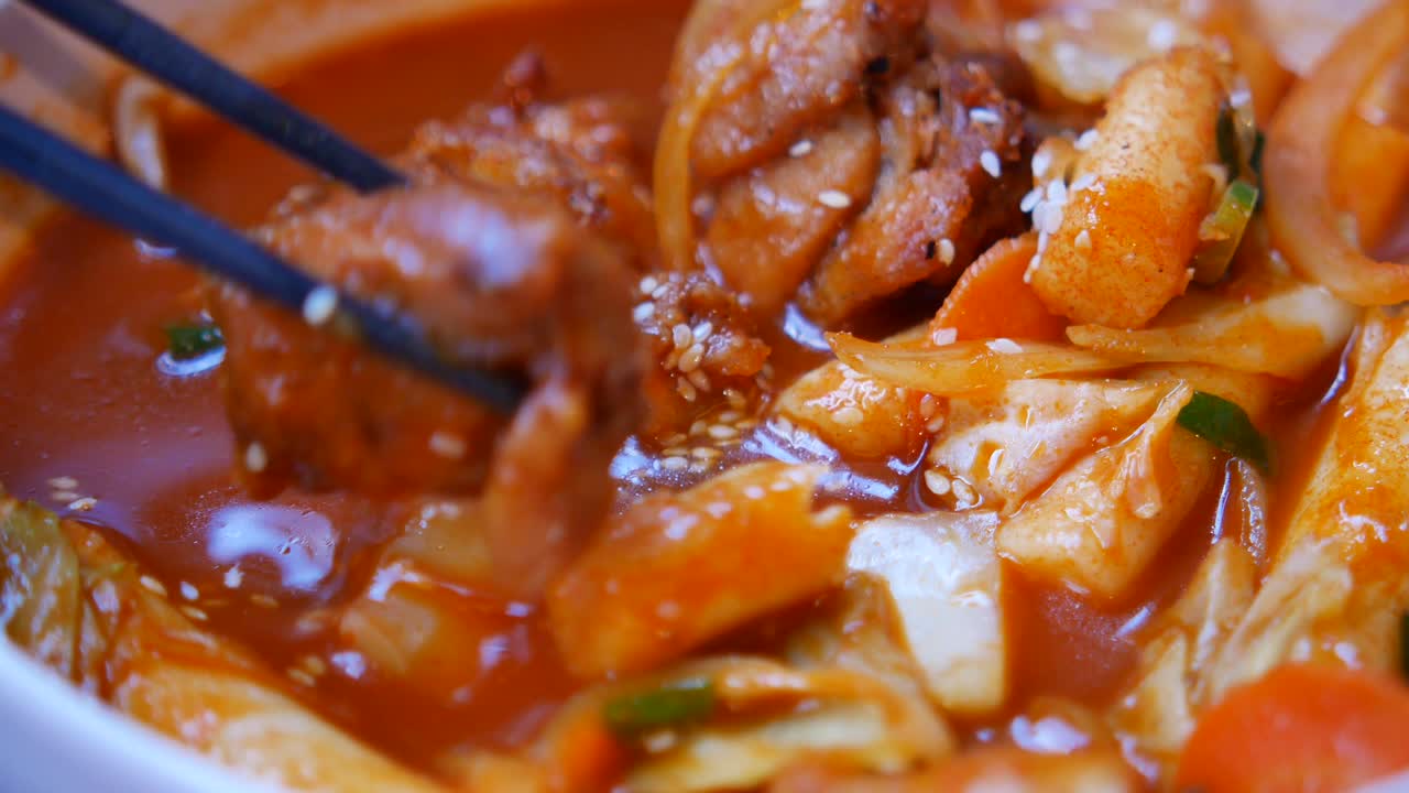 Gros plan sur du Tteokbokki coréen épicé avec du poulet et des gâteaux de riz