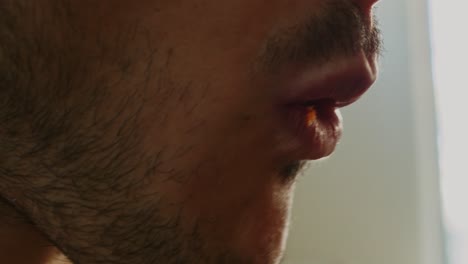 Man-with-stubble-on-his-face-takes-a-bite-out-of-a-grilled-cheese-sandwich-and-chews