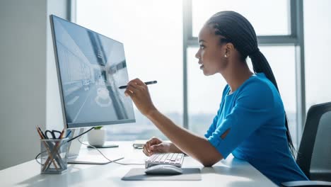 a focused young professional carefully illustrates a design concept on a computer monitor, showcasing creativity and technical skill in a modern workspace environment