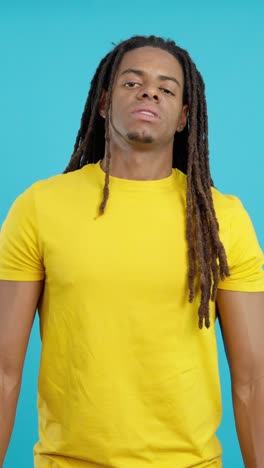 man with dreadlocks in yellow t-shirt