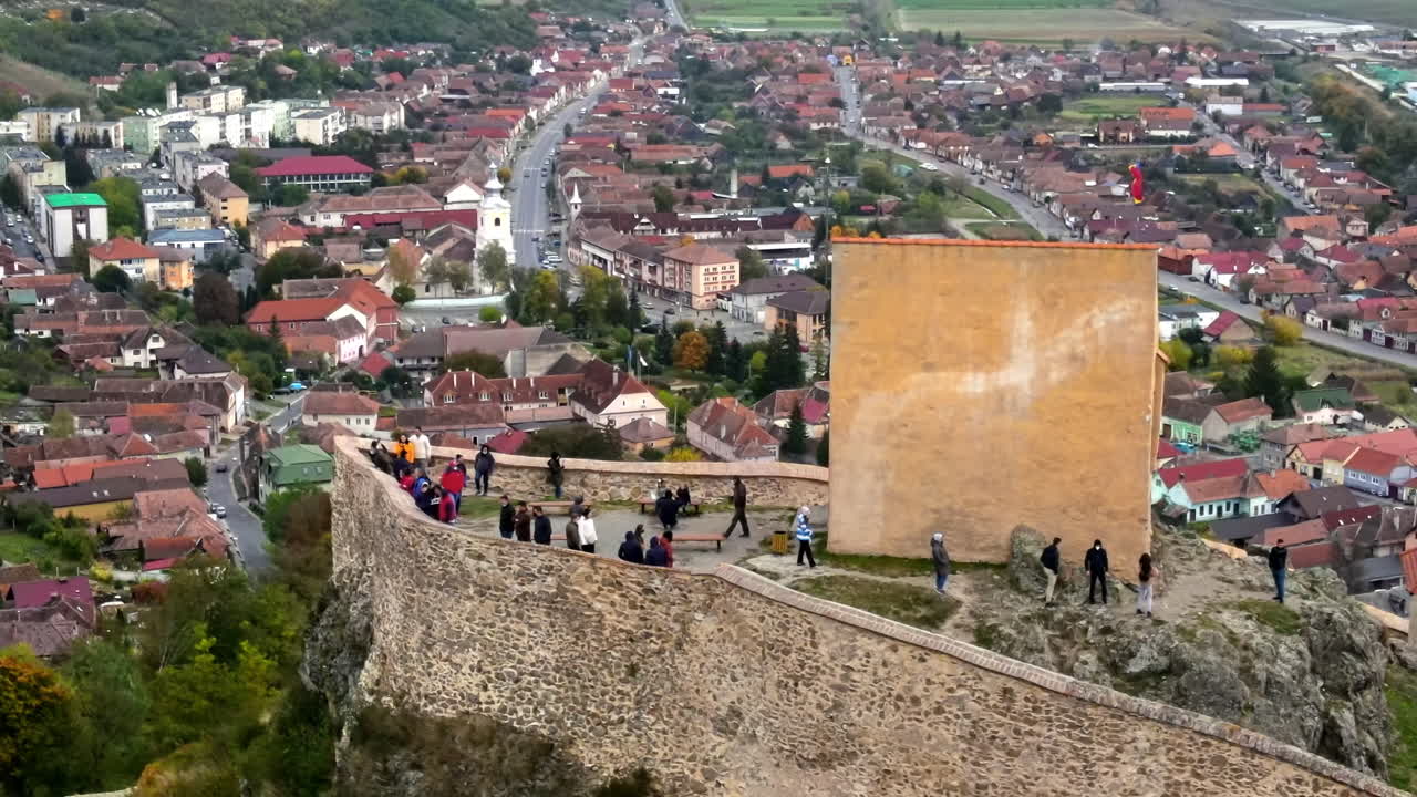 Aerial drone view of Rupea Fortress, Romania. Citadel located on a cliff, tourists, town