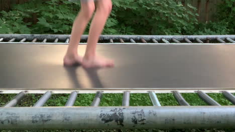 bare feet jump up and down on a trampoline in slow motion