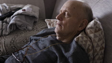 elderly man sleeping on a couch