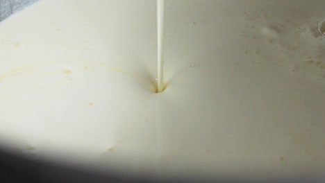 líquido de crema vertido en mezcla para pastel a cámara lenta