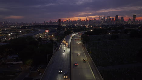 aerial view of freeway traffic entering new york city at night