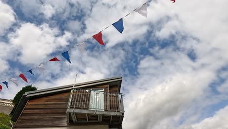 colorful flags waving near a wooden house