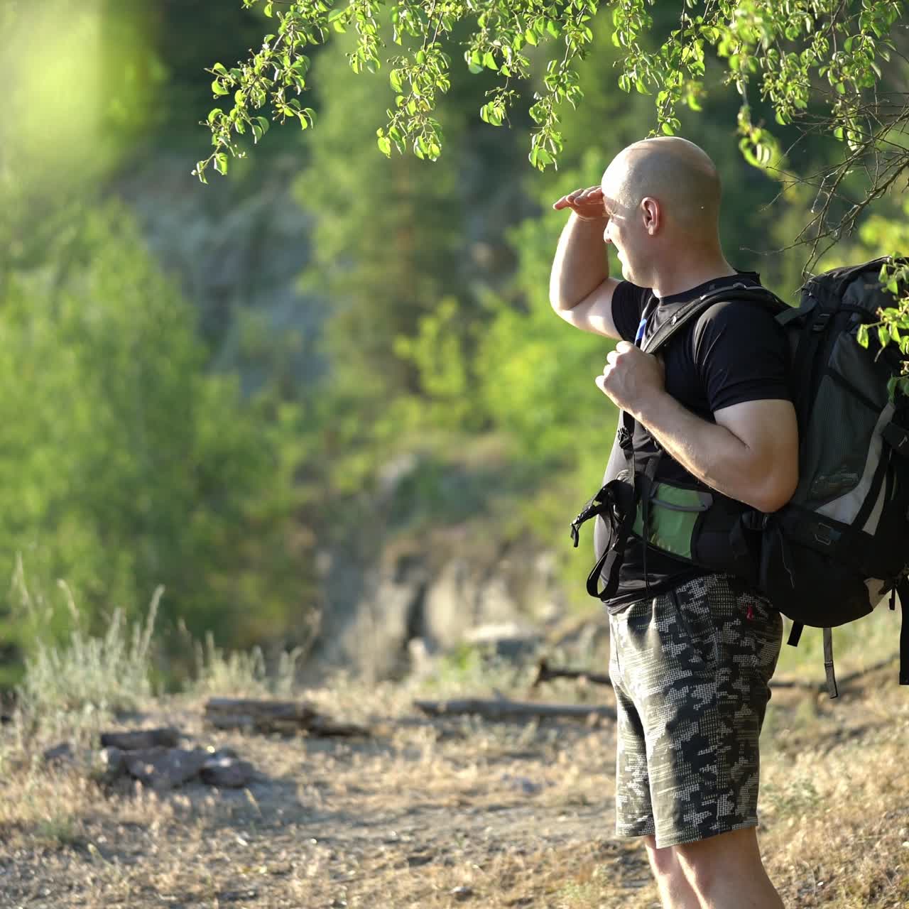 Aerial view of a young traveler with a backpack walking along a rocky path. Camping season. Travel concept.