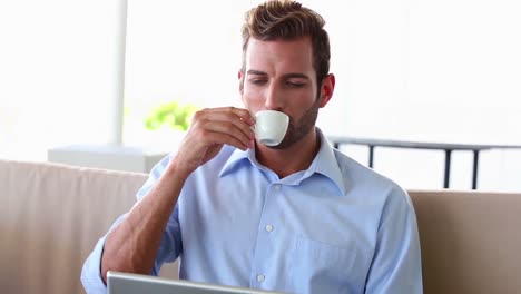 hombre de negocios trabajando en una computadora portátil y bebiendo espresso
