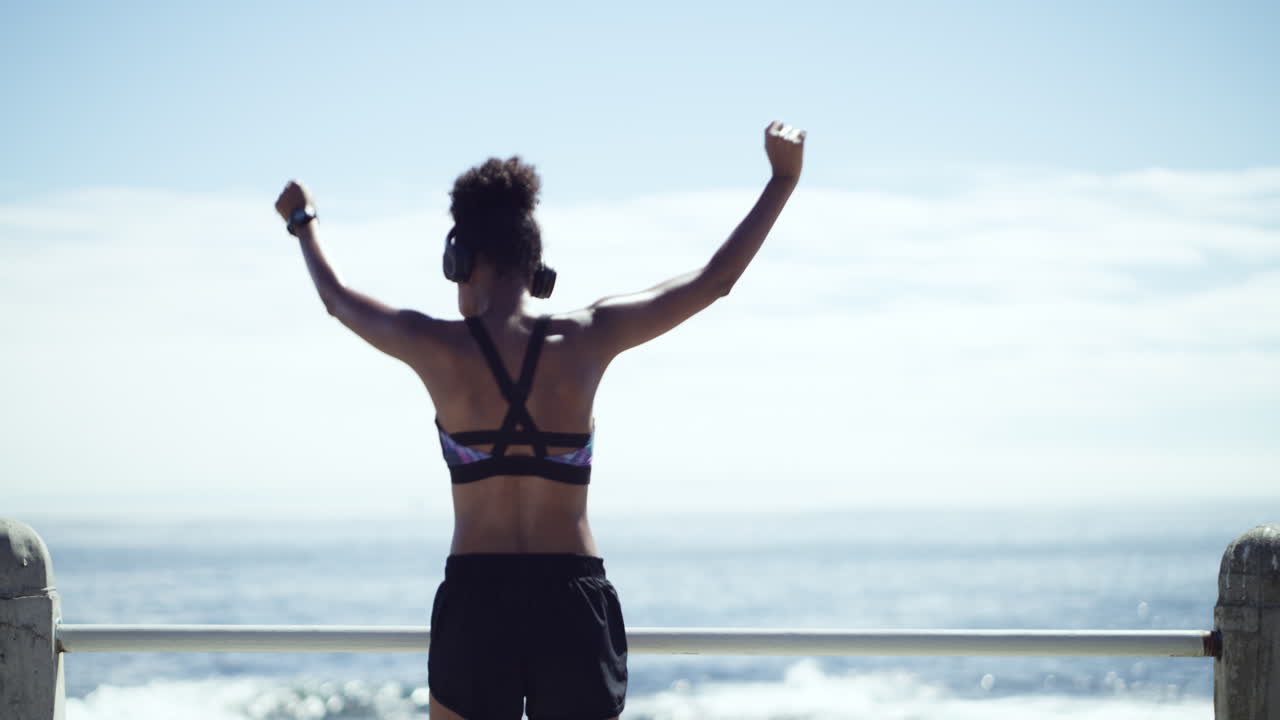 mujer bailando al aire libre junto al océano