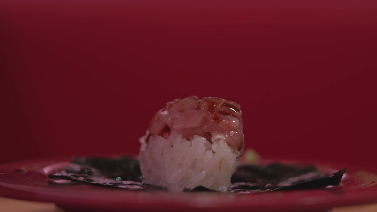 Primo piano di sushi fresco assortito disposto ordinatamente su un piatto da portata, che mostra frutti di mare colorati, riso all'aceto e un'elegante presentazione di cibo giapponese.