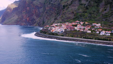 aerial view away from the jardim do mar town, on madeira - pull back, drone shot