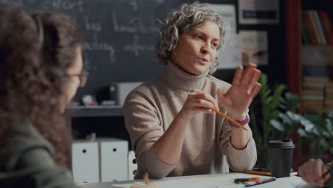 female teacher speaking with college students during english class