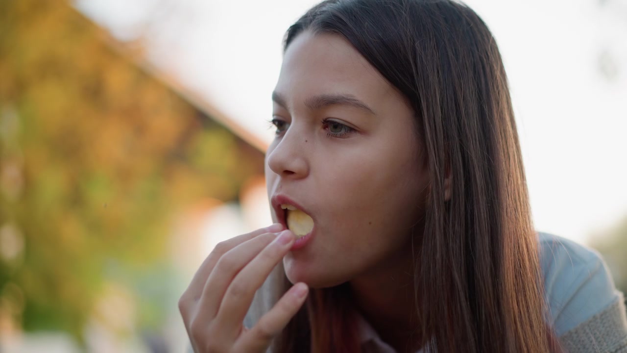 Young Woman Eating a Slice of Orange Outdoors