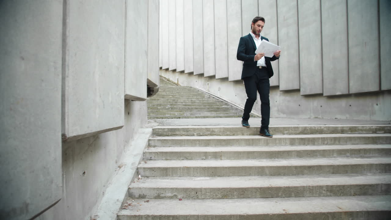hombre de negocios mirando documentos en la calle. ejecutivo masculino caminando para una reunión