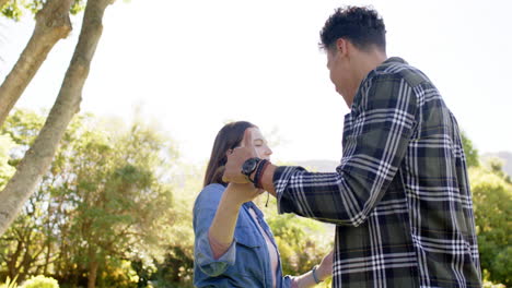 Happy-diverse-couple-dancing-in-sunny-garden,-in-slow-motion