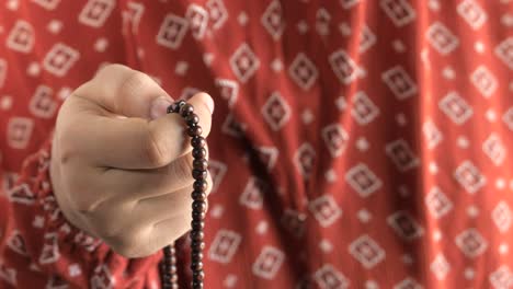 person holding prayer beads