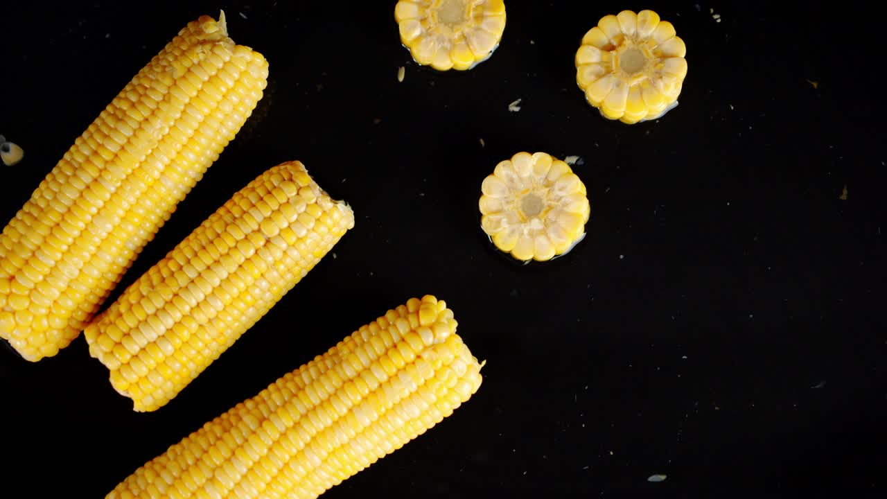 Pieces of corn fall on the water splashes.