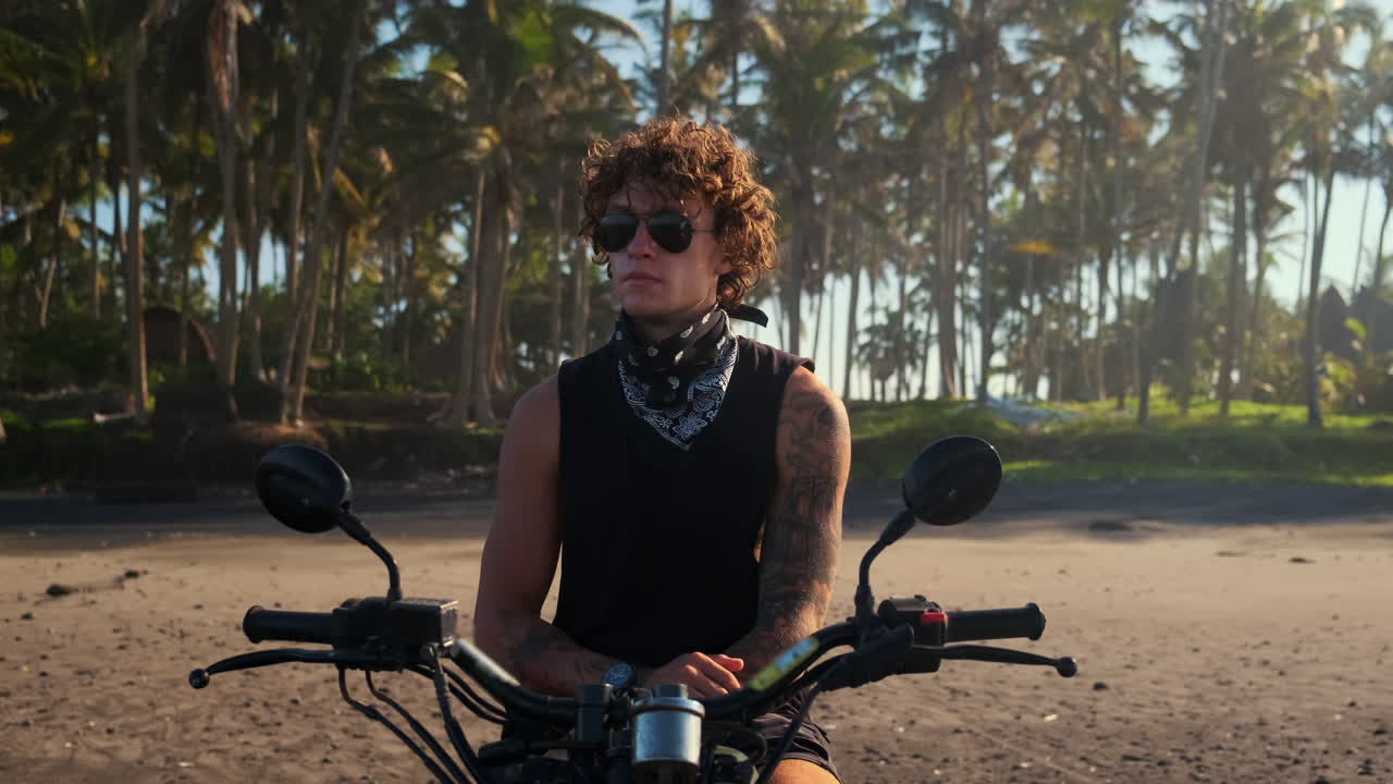 человек едет на мотоцикле по тропическому пляжу